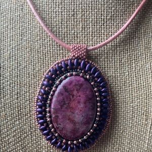 Purple/pink pendant on leather cord